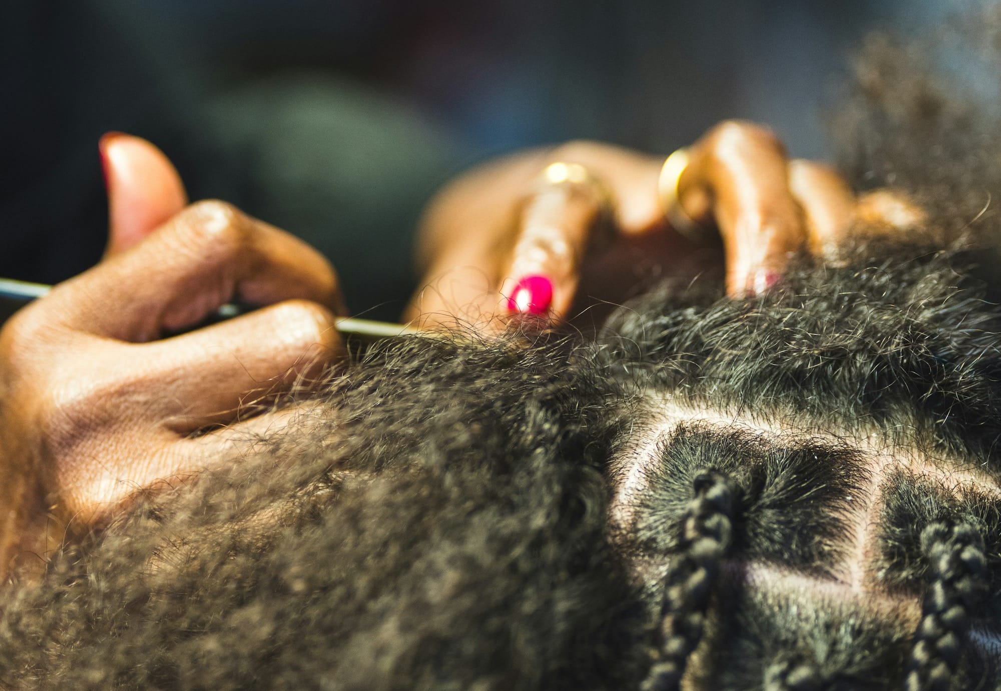 Hands braiding hair into small square sections.